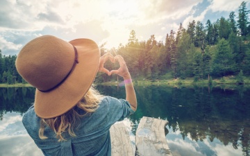 Eine Frau steht an einem Waldsee